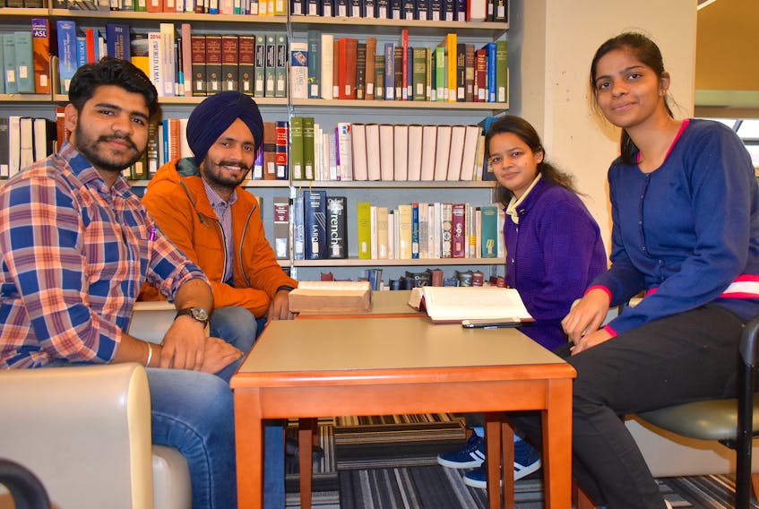 Varun Sharma, from left, Dildeep Singh, Shabadpreet Kaur and Harsimranjit Kaur sit in the library at Cape Breton University on Thursday. The first-year students are four of the more than 1,000 people from India now attending CBU. Overall, nearly half of CBU students are now from outside Canada.