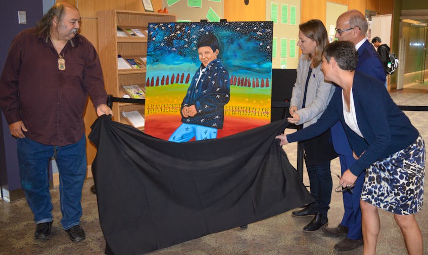 Artist Alan Syliboy, from left, Sarah Midanik, CEO of the Downie Wenjack Fund, CBU president David Dingwall and Catherine Arseneau, director of cultural resources with the Beaton Institute and CBU art gallery, unveil a portrait Syliboy painted of Chanie Wenjack for the occasion of the opening of the legacy room in Wenjack’s honour unveiled Friday at Cape Breton University’s library.