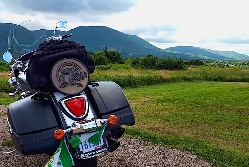 The coin is seen on the back of a bike in the Cape Breton Highlands during a Cabot Trail ride on Aug. 10. It wasn’t the best day for riding as they hit rain and thunder in Ingonish. “Worst thunder and lightning and hail I have ever seen,” said Mahoney.