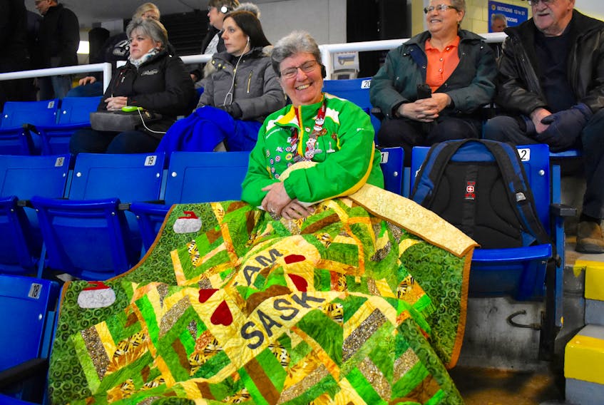 Super fan Sue Amundrud is turning heads at Centre 200 in Sydney where the Saskatchewan woman has become an arena landmark due to the bright green and yellow curling quilt she wraps herself in while watching the Scotties Tournament of Hearts. The retired educator, who hasn’t missed a Scotties for years, made the quilt prior to the competition. Amundrud says she makes a Team Saskatchewan quilt every year and give it to the curlers if they make it past the first round of the tournament.