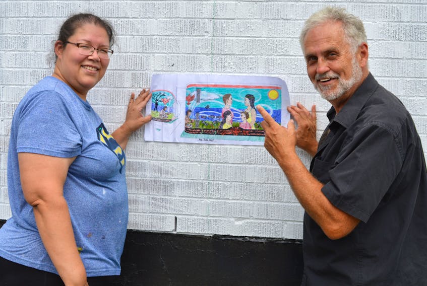 Mi’kmaq artist Loretta Gould, left, and Peter Steele go over the details of the mural they are creating on the side of the Undercurrent Youth Centre building in Sydney. Over the next few weeks, the two will be working together to create a mural on reconciliation.