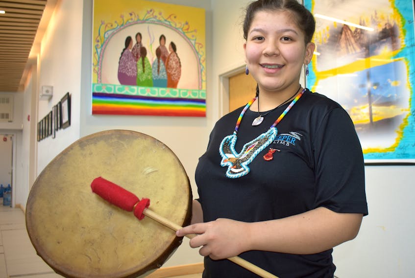 Bethany Cremo-Oakley stands outside the gym at Allison Bernard Memorial High School in Eskasoni on Monday holding a hand drum she made. The 16-year-old was one of about 200 high school students who performed a special arrangement of the song “Forgiveness” alongside musicians from the National Arts Centre Orchestra and Symphony Nova Scotia.