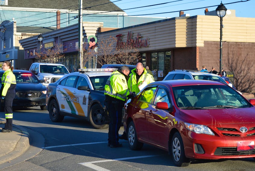 Const. David Vokey, left and Sgt. Joe Farrell investigate at the scene of a motor vehicle/pedestrian mishap Friday.  Cape Breton Post Photo