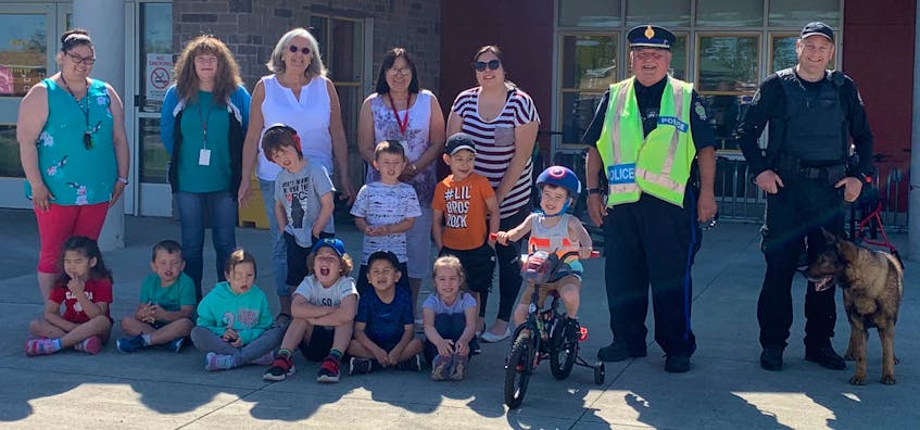The Cape Breton Regional Police held bike safety training on Wednesday at Membertou Elementary School. The children were taught about helmet safety, bike safety, crosswalks, stop, look and listen before crossing the street and looking in both directions for cars. Front row, from left, are Mali’San Doucette, Samuel Paul, Shanna Kiley, Elias Paul, Derek Christmas and Naomi Googoo. Middle row, from left, are Chasin Christmas, Nathan Johnson, Ty Ginnish and Jensen Knockwood. Back row, from left are Cinde Knockwood, Brenda Fogarty, Barbara Mathewson-McInnis, June Christmas, Desiree Francis, Sgt. Barry G. Gordon and K9 Assistant Sgt. Dale MacLean with K9 Const. Dakota.