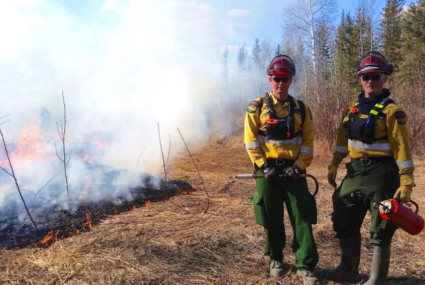 Shaun Waidson, left, 31, and his brother Mark Waidson, 23, of Reserve Mines, firefighters with Alberta Agriculture and Forestry wildfire branch in the Helitack crew, are shown at a fire scene in Northern Alberta. Shaun lives in Calgary and Mark still lives in Reserve Mines but both brothers work seasonally fighting forest fires in Alberta.