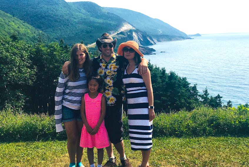 Stéphane Poitras and girlfriend Shanshan Liu pose with Poitras’ daughter Chloé, left, and Liu’s daughter Catherine during last summer’s trip to Cape Breton.