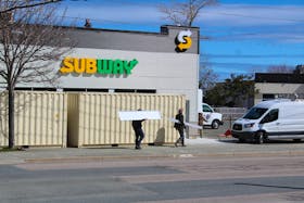 Two men carry building materials into the New Waterford Subway on Plummer Avenue on Thursday. Anticipated opening for the new franchise location was expected to be December but delays have caused the opening to be pushed to June 1 “at the latest” according to owner Emily Pelley.