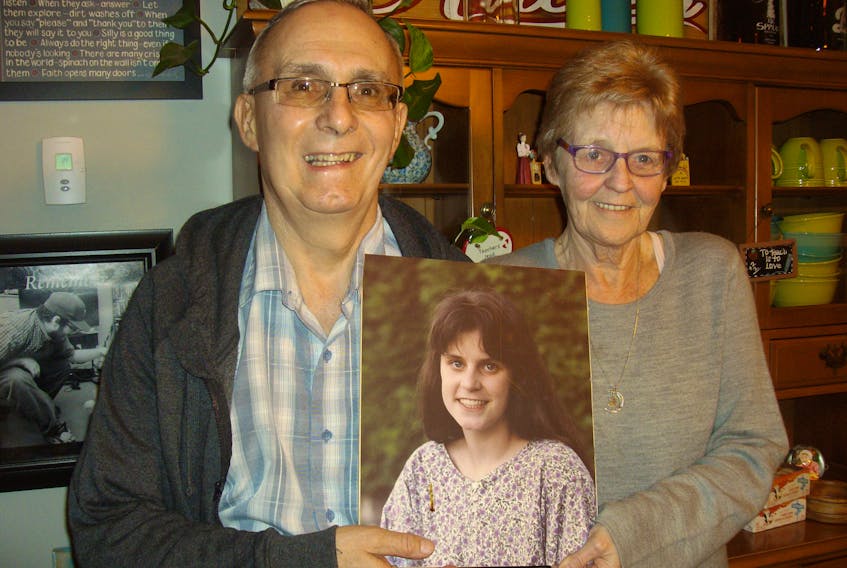 Brian and Nancy Young in their Meech Avenue home hold a photo of their daughter Carmen. (Gordon Sampson)