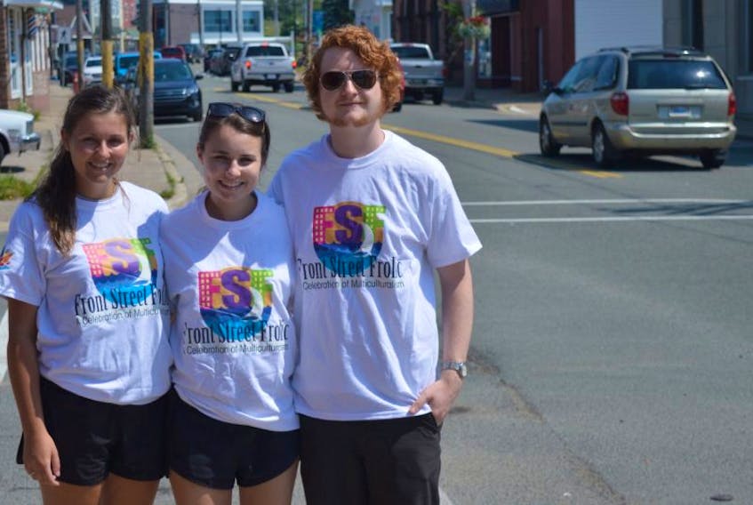 From left, Hannah White, Shannon MacDonald and Josh Boudreau stand near the location of this year’s Front Street Frolic in North Sydney. The new multiculturalism festival will take place on Tuesday on Commercial Street.