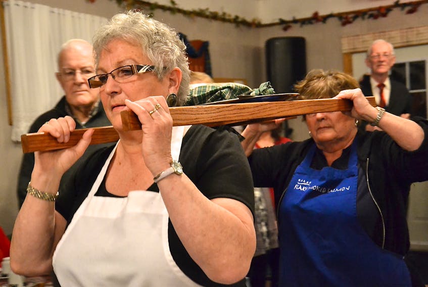 Ann Hanna, front, and Mary Sumners paraded a plate of haggis around the dining room at the Frenchvale Senior Citizens’ Club in this 2014 file photo.