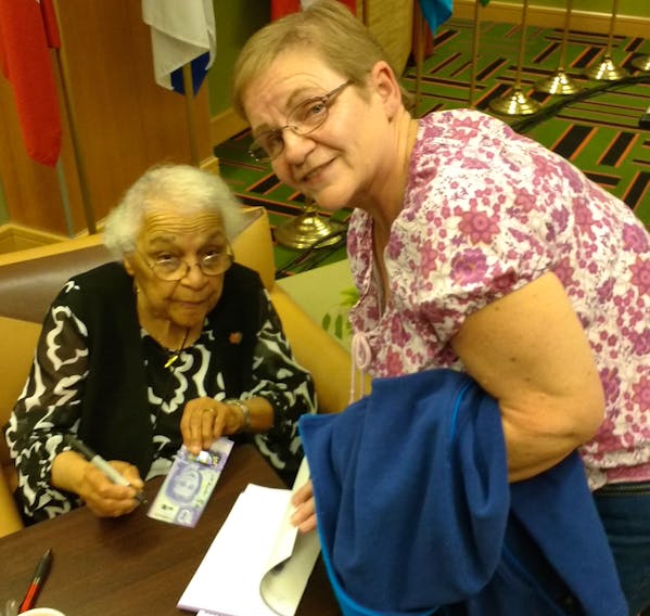Wanda Robson, the sister of Viola Desmond, who is featured on the Canadian $10 bill, autograph’s a bill for Cape Breton Post columnist Lila Carson, during an unveiling of the bill at Cape Breton University in November 2018.