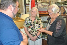 John Wales of the North Nova Scotia Highlanders Regimental Museum presents Pte. Robert McDonald’s First World War Victory Medal to McDonald’s granddaughters Carol Pereira, centre, and Sandra Corbeil. It ends a mystery that started in the 1970s when a young woman found the medal while snorkeling off Hawaii.