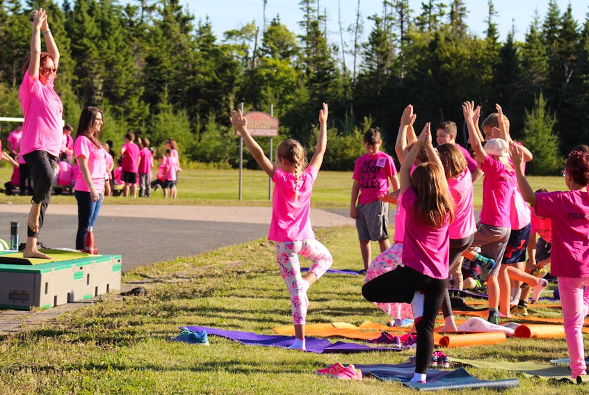 Donna Lee Parker, music teacher at Riverside Elementary School, guides students through a tree pose during a short yoga practice during Pink Shirt Day activities at the school Thursday.