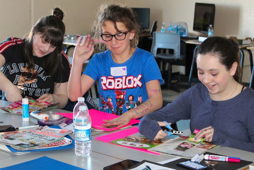 From left, Brynn White, Ella Penney and Vienna Matheson work on collages during a one-day workshop on self-esteem at Oceanview Education Centre in Glace Bay during March break.