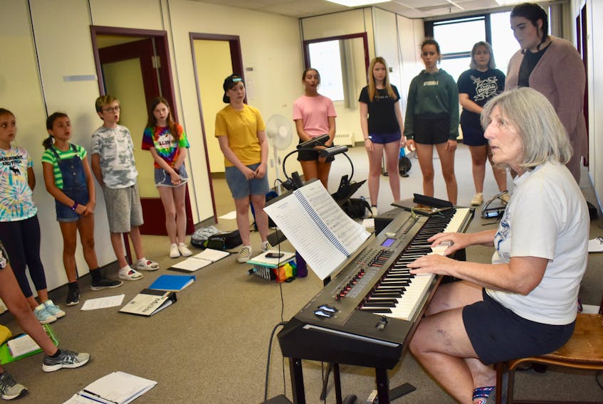 Barb Stetter, foreground, the musical director of the upcoming musical "Matilda," which will run at the Savoy Oct. 4-6, runs through vocal exercises with some cast members during a recent rehearsal.