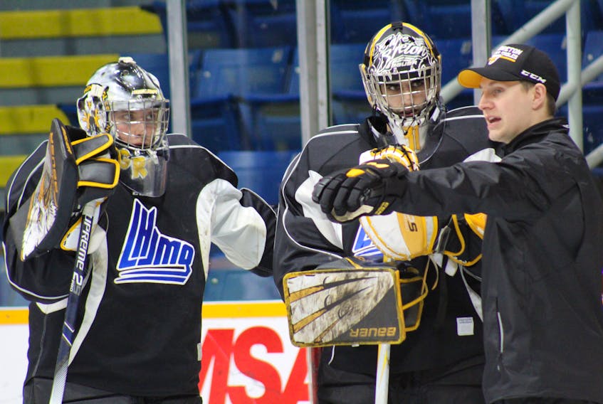 Cape Breton Screaming Eagles goaltending and video coach Charles Grant, right, gives instruction to netminders William Grimard, left, and Kevin Mandolese during team practice on Monday at Centre 200 in Sydney. Grant is in his first season with the team.
