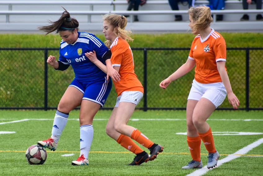 Bedford’s Anna McCormick, left, ran into double trouble as she attempted to clear the ball from her team’s zone during play late in the second half in a match against Cape Breton FC in the Nova Scotia Soccer League’s U18 “A” girls division at the pitch at Open Hearth Park on Sunday. Not only did McCormick and her Bedford teammates have to play into a strong headwind in the second half, but they faced tenacious coverage from the hosts, such as that displayed in the above photograph by Sasha MacDonald, centre, and Paige MacInnis. Cape Breton FC was leading 5-2 in the final minutes of the match. The victory gave the squad a 5-0 record in 2019 summer league play.