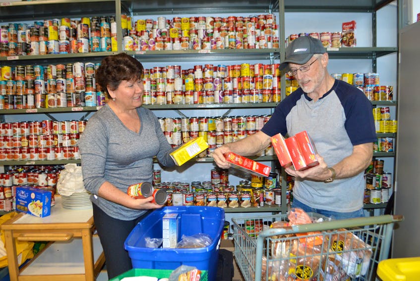 Gloria Cantwell, left, of Sydney River, and Lloyd Tallman, of North West Arm, volunteers at Loaves and Fishes, Sydney, stock some shelves Tuesday. Marco Amati, executive director, said they get lots of non-perishable food donations, right now there is a great need for monetary donations so they can purchase perishable foods such as vegetables as well as meat and fish for their freezer. Amati said their numbers in for a hot meal have gone from 128 a day to 178 a day, some days hitting 200. The increase began last year partly due to the influx of international students in the area but also now to the time of year, with winter here.