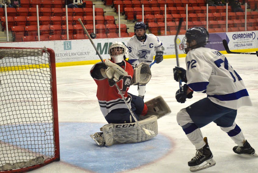 Nick Burke of the Sydney Academy Wildcats, right, prepares to bat the puck out of the air as Glace Bay Panthers goaltender Darian MacInnis watches the puck during opening night of the Cape Breton High School Hockey League at the Membertou Sport and Wellness Centre. Burke would score on the play. Glace Bay won the game 6-2.