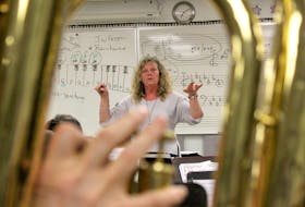 Conductor Laura Mercer is seen through musician Earle MacLean’s tuba as she leads the Second Wind Community Concert Band through rehearsal Thursday at Malcolm Munroe Memorial Middle School in Sydney River. The band was preparing for its upcoming “Here Comes Summer” show, which takes place Friday at Cape Breton University’s Boardmore Theatre.