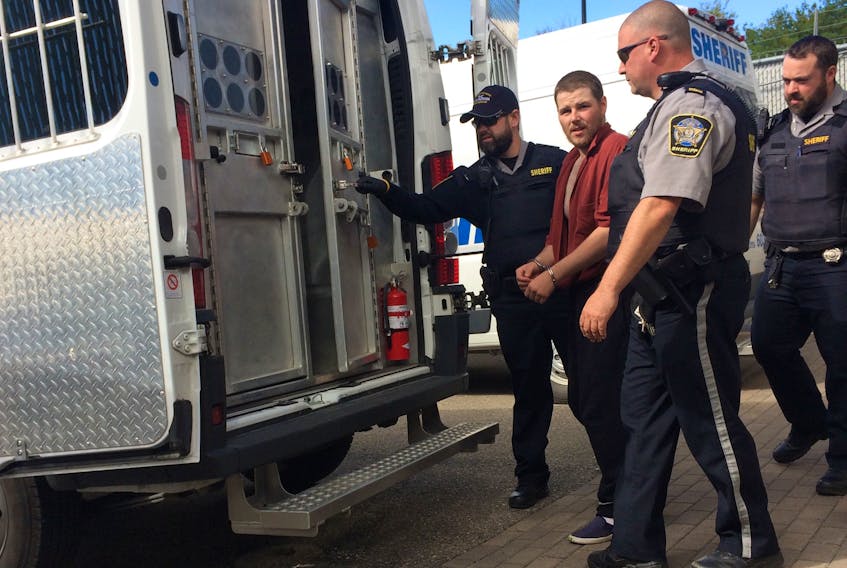 Sheriff deputies escort Darren Joseph MacGillivary, 23, to a transport van Tuesday after he appeared in provincial court on a charge of aggravated assault in relation to the beating of a 81-year-old man. He will return to court Friday for a bail hearing.