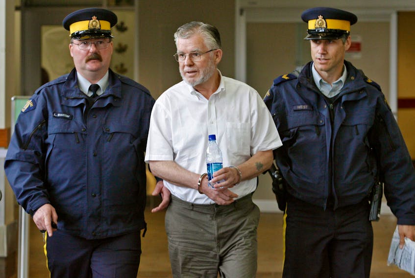 RCMP officers escort former Port Hawkesbury businessman and hockey executive Fen MacIntosh through the Halifax Stanfield International Airport on Thursday, June 7, 2007.