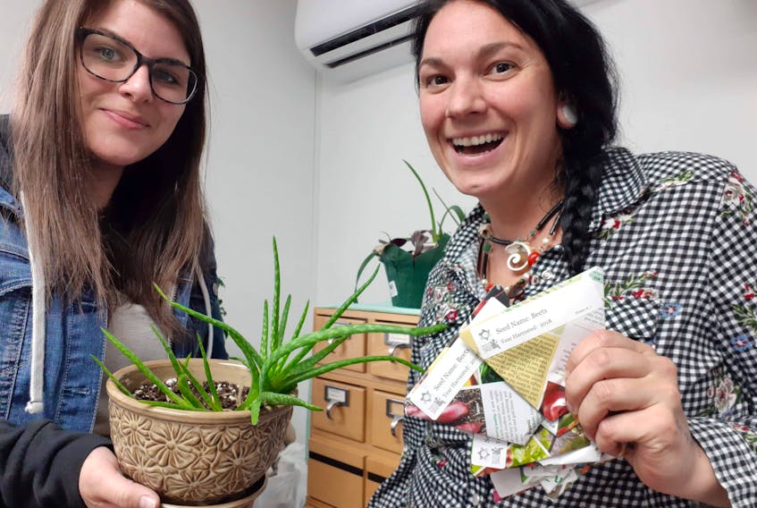St. Peter’s Library assistant Ashley Dempsey, left, and Tara Paon of the Community Skill Exchange-Richmond County TimeBank are preparing to open Richmond County’s community seed exchange on Saturday at the St. Peter’s Library.
