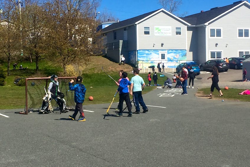 A group of children play road hockey in the parking lot of the Whitney Pier Youth Club (Boys and Girls Clubs of Cape Breton) in Whitney Pier on May 30. The organization is getting funding together for the phase four of their renovations, the final one, for the outdoor recreation area which will include a volleyball court and hockey rink.