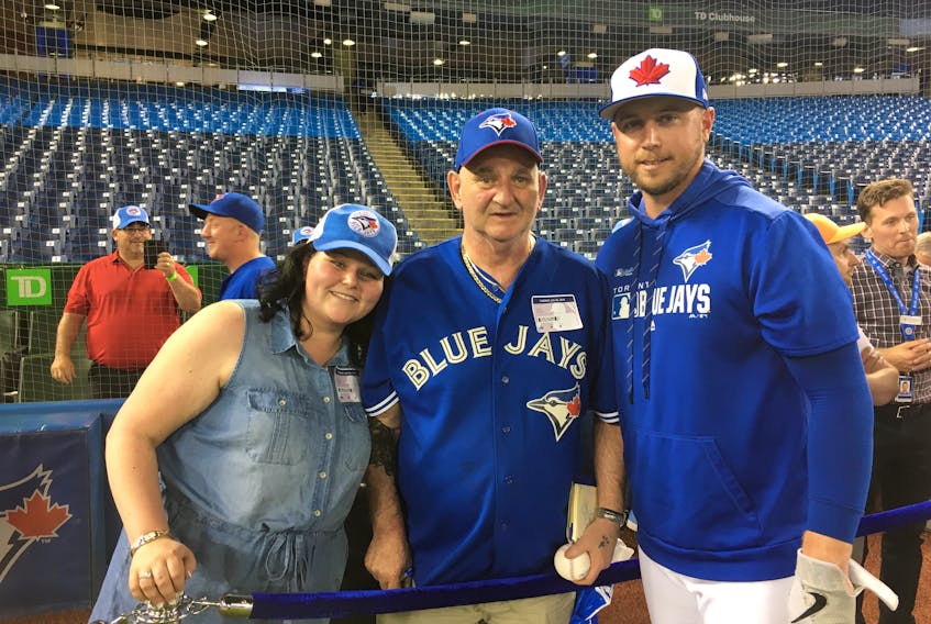 Natasha McGean and her father Glen McGean, diagnosed with terminal lung cancer, both of Sydney, pose with Blue Jays first baseman Justin Smoak, Glen’s favourite player, at a game in Toronto Tuesday.