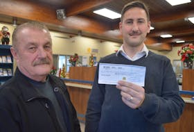 Yianni Harbis, right, manager, branch and commercial banking for the Sydney Credit Union on Townsend Street, stands with Greg MacPhee, a Cape Breton Regional Municipality building inspector, while holding a check the credit union made out for a Cape Breton Firefighters Burn Care Society fundraiser hosted by Cape Breton Regional Municipality building inspectors 11 years ago. MacPhee found the obviously misplaced check last week and says he’s grateful the credit union honoured it after all this time.