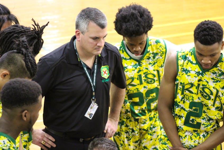 Ed MacPherson, centre, is shown with his St. Patrick’s Catholic High School basketball team in a huddle during the second quarter of their game against L’Externat Saint-Jean-Eude on Monday. The St. Patrick’s won the game, 74-33.