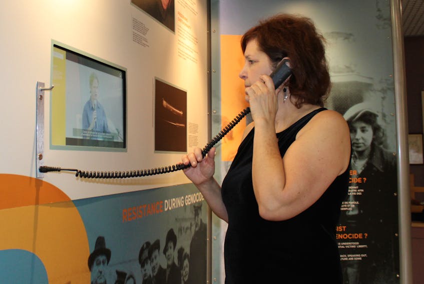 Diane Lewis, a teacher with the Cape Breton-Victoria Regional Education Centre, tests the interactive capabilities of the United Against Genocide exhibition at Victoria Park Armouries. The exhibition is in Sydney until Nov. 14.