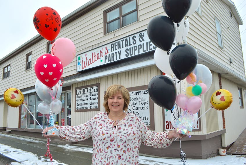 Donna Burt, owner of Walter’s Party Supplies, gets in the party mood in front of the business on Sheriff Avenue in Sydney with balloons — her favourite part of the business. The business, which has been in the family for 38 years, is up for sale.
