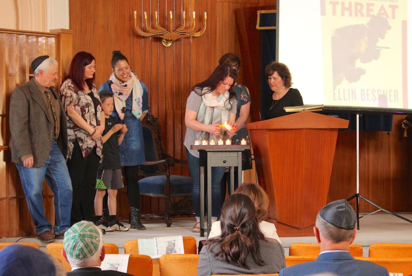 Kara Doyle (second from right) lights a candle during Yom Hashoah (Holocaust memorial service) on May 5 at Temple Sons of Israel in Sydney. The candles were lit in memory of those who died during the Holocaust and guest speaker this year was author Ellin Bessner, whose book Double Threat is about Canadian Jewish Second World War veterans. Pictured here, from left: Fred Blufarb, Maura Lea Morykot, Michael Christmas, Heather MacDonald, Kara Doyle, (behind Doyle) Pam Van Dommelen and Diane Lewis.