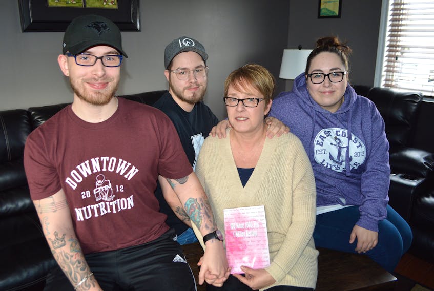 Shelly Breen, centre, 49, of River Ryan, holds the book ‘100 moms 1000 tips 1 Million Reasons’ by author Doreen Coady formerly of Sydney and now of Elmsdale, which she’s featured in, while gathered with three of her children, from the left, Trent, 23, Nicholas, 20, and Kendall 25.