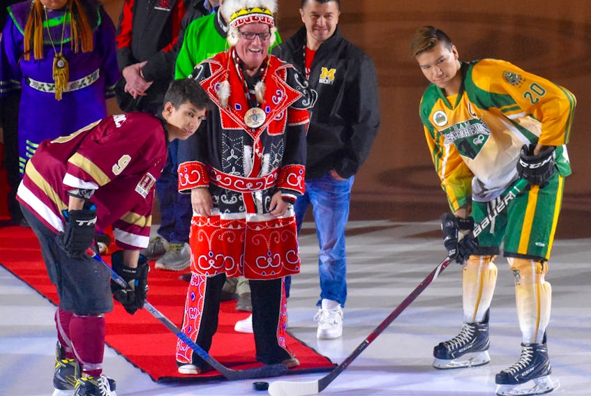 Membertou First Nations Chief Terry Paul drops the puck to officially open the 2018 National Aboriginal Hockey Championships on Sunday at the Membertou Sport and Wellness Centre, where the 20-team, male and female tournament is taking place through May 12. The players taking part in the puck drop are New Brunswick captain Jayden Hickey, left, and Saskatchewan’s Leighton Burns Marion.