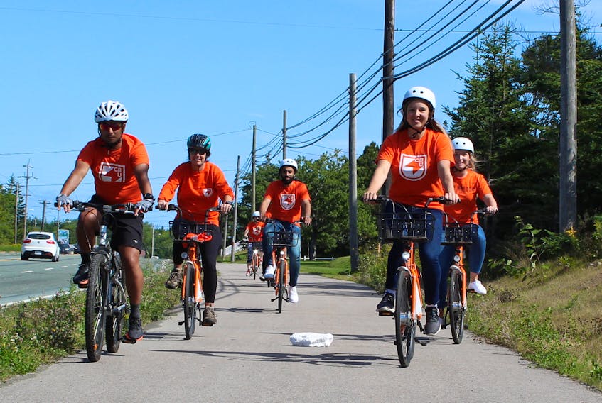 Students and staff of Cape Breton University are shown riding along Grand Lake Road on Friday as part of the inaugural ride of a bike share initiative at the university. The program will see a fleet of 25 bikes available to the CBU community free of charge.