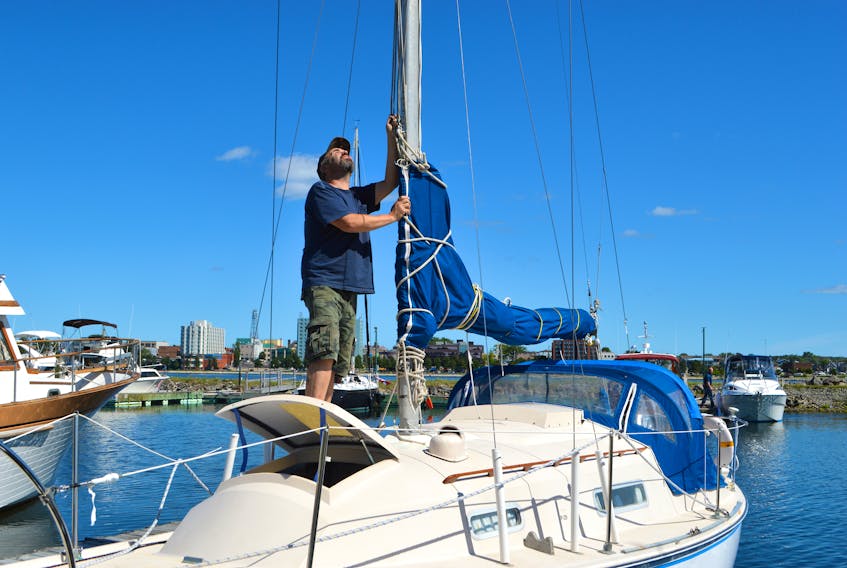 Lorne Currie of Westmount, an executive member of the Dobson Yacht Club, helps check the mast of a sailboat owned by member Dan MacDonald, at the dock on Friday. Currie said members were asked to check to ensure their boats were secure in preparation for the storm, which Environment Canada issued a hurricane warning for at 3 p.m. Friday.