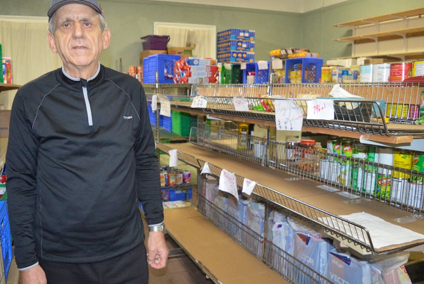 Lawrence Shebib, co-ordinator of the North Sydney Community Food Bank, stands by the nearly empty shelves at the North Sydney location, Tuesday. The food bank is running low on supplies and is in need of donations to help the 170 families it serves on average each month.