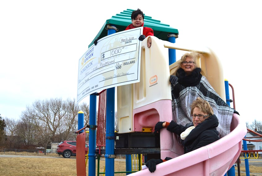 Cathy MacIntyre, top, chair of the Marcia Fiolek Memorial Playground in Dominion, holds a cheque for $1,000 from the Dominion Credit Union. The money will be used to help make the playground all-inclusive. Also in the photo are committee member Janine Fiolek, centre, and Rina Gouthro, manager of the Dominion Credit Union. The committee is working on various fundraisers and have also applied for a grant.