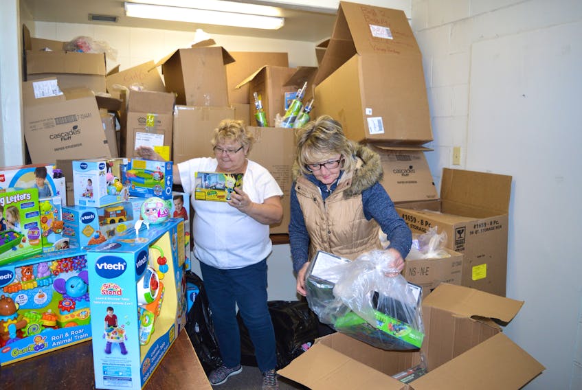 Susan Aucoin, left, toy shopper for Combined Christmas Giving, and Shelley McLellan, chairperson, sort toys as they prepare the Christmas packages for those people who applied for assistance. Packages can be picked on Saturday from 10 a.m.-4 p.m. at the New Waterford fire hall.