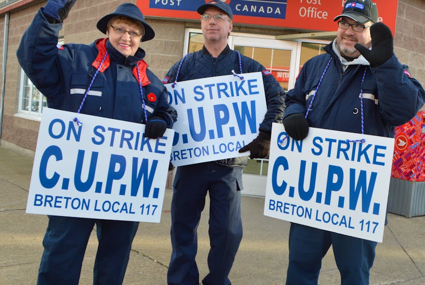 Members of the Canadian Union of Postal Workers Breton Local 117 including, from left, Mae James, a part-time PO4 clerk, Morgan Fudge, full-time retail PO4 clerk and Joe Reno, a part-time PO4 clerk, picket in front of the Canada Post building in Sydney on Thursday. Members of the CUPW are without contract and have been holding rotating strikes across the country.