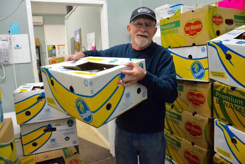 Robert Dolomont, a volunteer at the North Sydney Community Food Bank, lifts a box of non-perishable food items at the North Sydney location on Thursday. The local food bank has received overwhelming support after making a plea to the community for donations.