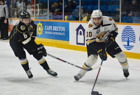 Shawn Boudrias of the Cape Breton Screaming Eagles, right, skates the puck into the offensive zone as former Screaming Eagle Noah Laaouan of the Charlottetown Islanders slashes his stick during Quebec Major Junior Hockey League action at Centre 200 on Wednesday. Cape Breton won the game 6-2.