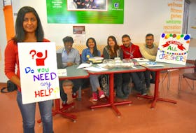 Jaya Kaushik holds a sign at a help desk set up by the multicultural hub at Cape Breton University. The 21-year-old business student is one of about 500 people from India who enrolled at CBU this semester. She is joined by compatriots George Innasi, from left, Farhin Mansuri, Astha Aggarwal, Rohit Verma, and Pamkaj Kumar Sharma.