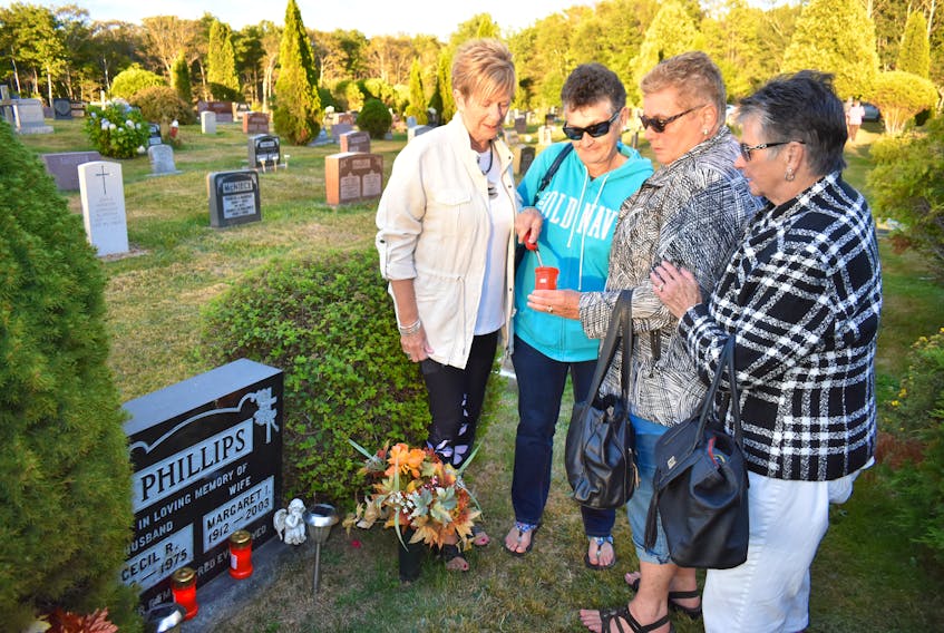 From left, Jean Gillis of Sydney at the grave of her parents, Cecil and Margaret Phillips, is joined by Florence Oakes of North Sydney, Linda Phillips of Greenwood, N.S., Jean’s sister-in-law, originally from North Sydney, and Carol Quirk of North Sydney. Oakes and Quirk are Linda’s sisters.