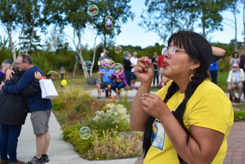 Andrea Dennis blows bubbles into the air in memory of those she lost to suicide. The Membertou woman, who has lost a son, a brother and a first cousin to suicide, was among those who gathered at Membertou’s Heritage Park on Sunday afternoon to acknowledge World Suicide Prevention Day, held across the world every Sept. 10.