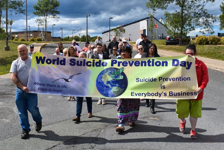 A procession marking World Suicide Prevention Day makes its way through Membertou on Sunday afternoon. About three dozen people took part in a 90-minute ceremony during which those who took their lives by suicide were remembered and the call raised for more awareness about the mental health issue and its often fatal consequence.