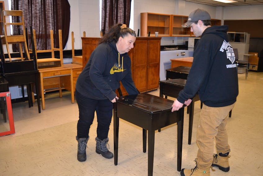 Jeanette MacDonald, left, secretary of the Glace Bay Y's Men's and Women's
Club, and club member Adam Verge move desks in the former Morrison school. The club purchased the building from the International Centre for English Academic Preparation and plans to rent the various rooms within the building.