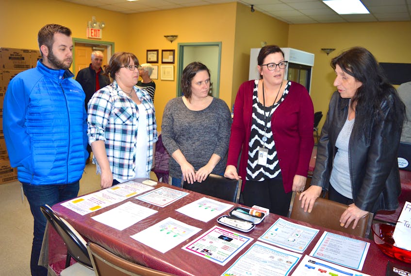 Christine Porter, right, executive director of the Ally Centre of Cape Breton, discusses the centre’s supportive space in the Glace Bay Food Bank with Department of Community Services workers during an open house last week. From left, intake care worker Steve Campbell, job developer Jennifer Huntington and career counsellors Kelly Campbell and Amy MacDonald.